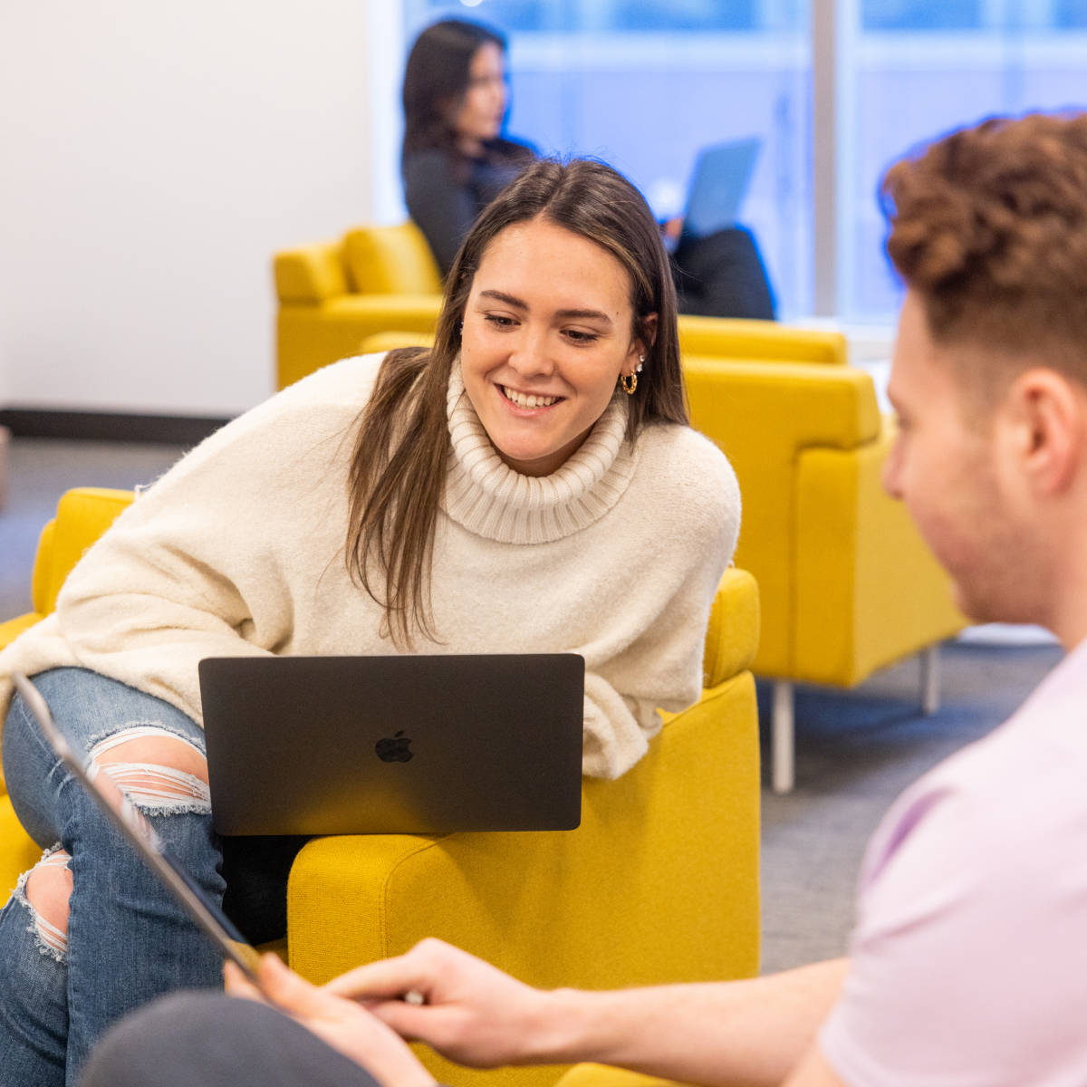 Students smiling while working on computers