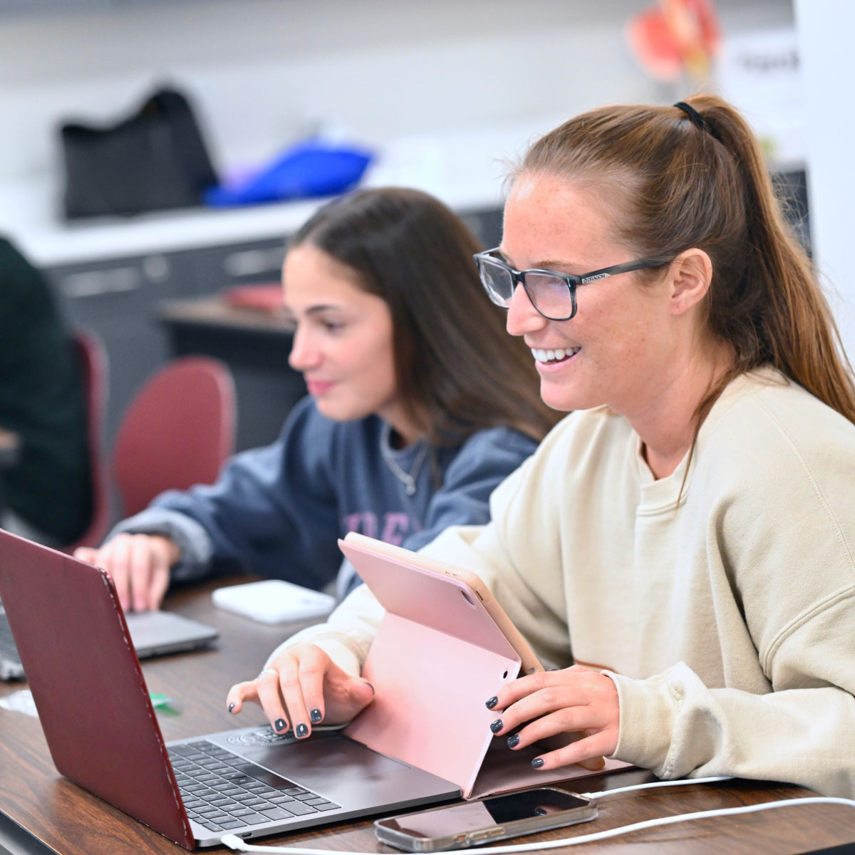 Female students using laptops during class